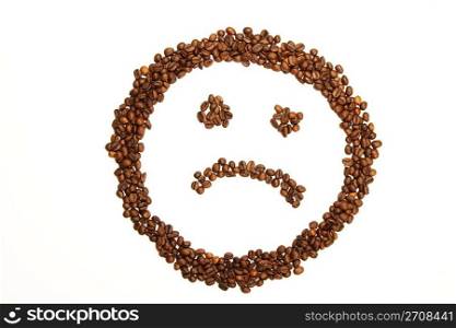 sad coffee smiley. sad smiley made of coffee beans on white background