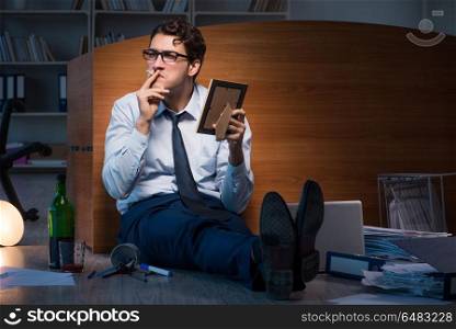 Sad employee in office missing his wife after divorce separation