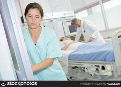 sad female nurse at hospital corridor
