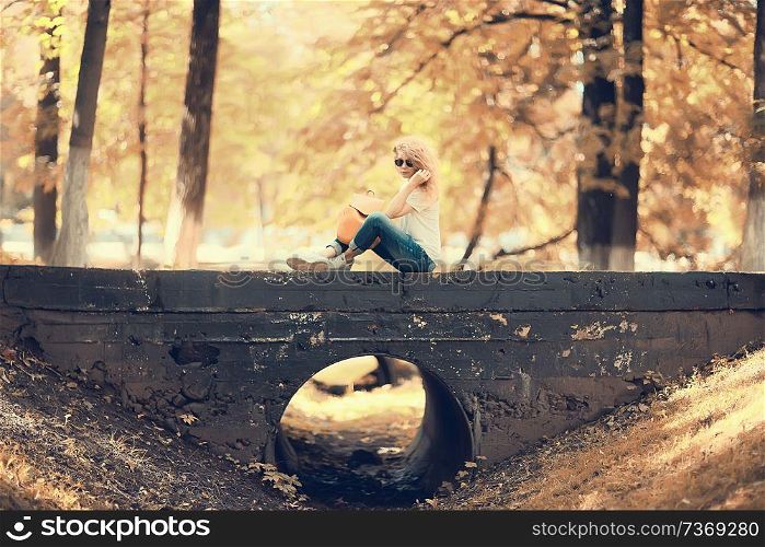 sad girl on the river bank, beautiful adult woman sitting on the riverbank concept expecting sadness