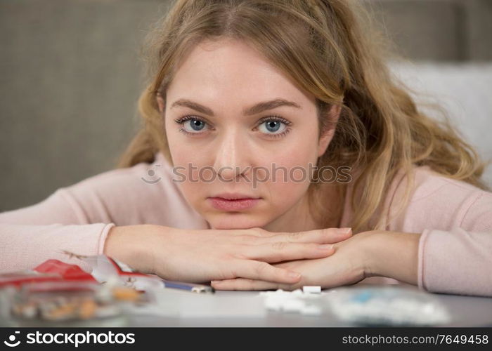 sad girl with hand rolling tobacco and associated equipment