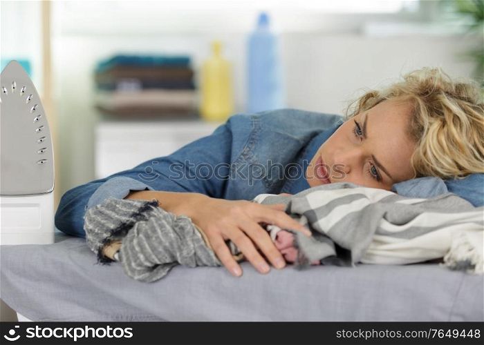 sad housewife with laundry next to washing machine