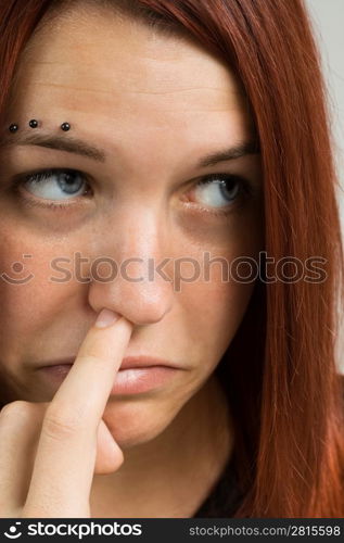 Sad looking girl picking nose