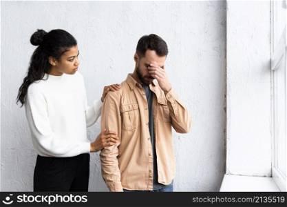 sad man being consoled by woman group therapy session