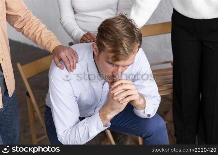 sad man sitting chair group therapy session