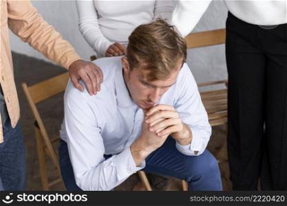 sad man sitting chair group therapy session