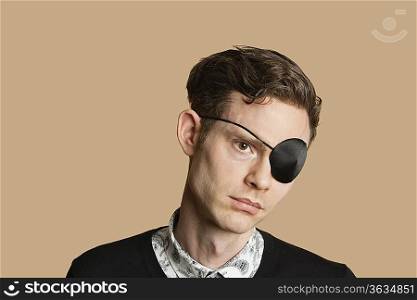 Sad mid adult man wearing eye patch over colored background
