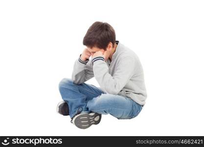 Sad preteen boy sitting on the floor isolated on a white background