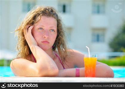sad pretty bored woman is boring in the hotel swimming pool