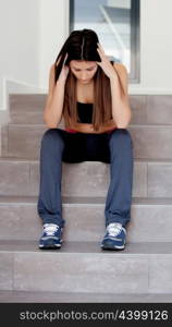 Sad teenager girl sitting on the stairs at home
