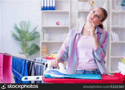 Sad woman ironing clothing at home. The sad woman ironing clothing at home