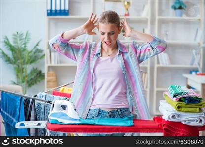 Sad woman ironing clothing at home. The sad woman ironing clothing at home