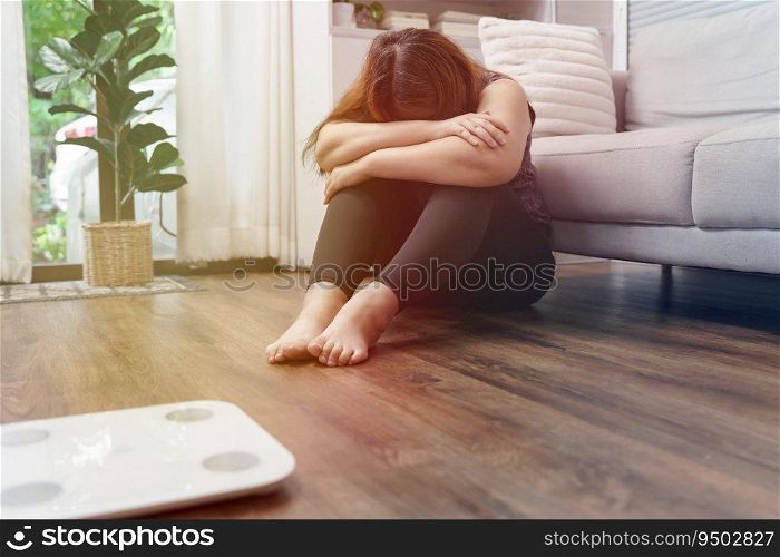 Sad woman with fat upset bored of dieting Weight loss fail  Fat diet and scale sad asian woman on weight scale at home weight control.