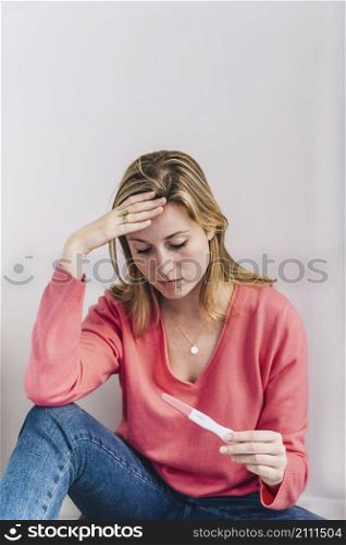 sad woman with pregnancy test