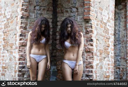 Sad women in white underwear on a brick wall