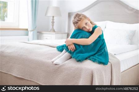 Sad young girl sitting in the bedroom