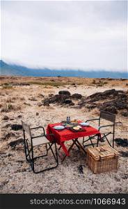 Safari outdoor picnic with African Tanzanian cuisine with baked Chapati nan flatbread on red table - African lunch meal for safari trip