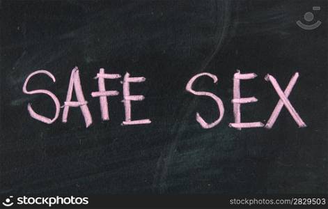 safe sex title handwritten with a white chalk on a school blackboard with strong eraser smudges