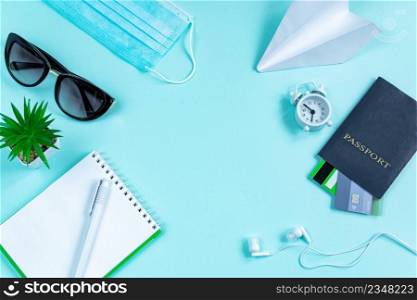 Safe travel concept during the coronavirus pandemic. Passport, medical mask and sunglasses on a blue background. Flatlay, banner format.. Safe travel concept during the coronavirus pandemic. Passport, medical mask and sunglasses on a blue background.