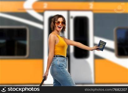 safe travel, tourism and health care concept - happy laughing young woman with air ticket, immunity passport and bag walking over train background. happy woman with air ticket and immunity passport