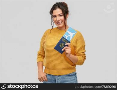 safe travel, tourism and health care concept - happy smiling young woman with air ticket and immunity passport over grey background. happy woman with air ticket and immunity passport