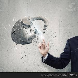 Safety concept. Businessman crushing stone lock with finger touch