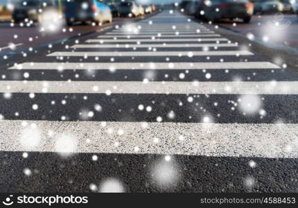 safety, traffic laws, highway code and road sign concept - close up of pedestrian crosswalk on city car parking over snow