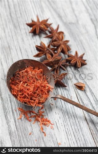 saffron in old spoon with anise on wooden background. saffron in spoon with anise on wooden background