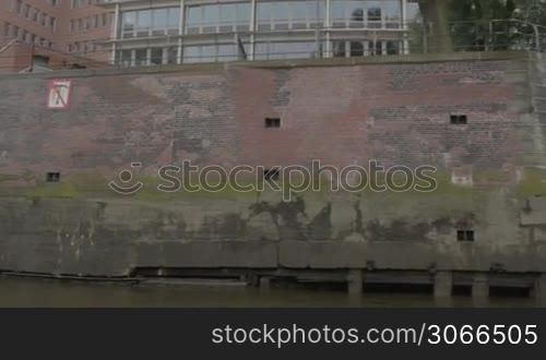 Sail along the red-brown old brick wall on the Elbe river in Hamburg