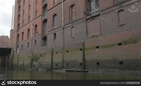 Sail along the red-brown old brick wall on the Elbe river in Hamburg.