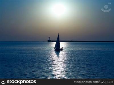 Sail boat against sea sunset. Blue marine landscape.