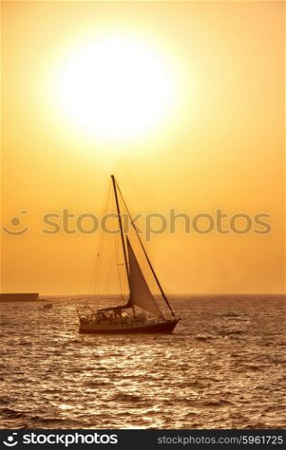 Sail boat against sea sunset. Colorful marine landscape.