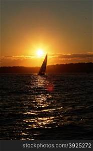 Sail boat at sunset on the ocean.. Sunset on the ocean.