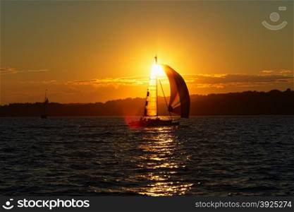 Sail boat at sunset on the ocean.. Sunset on the ocean.