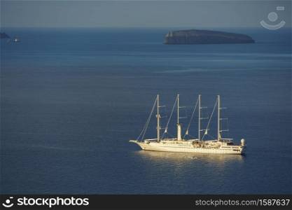 Sail boat cruising in deep blue waters near Santorini island, Greece.