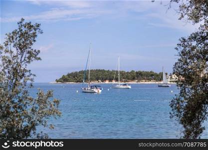 Sail boats and clear blue water in a Croatian bay, golden cape