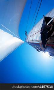 Sail over clear blue sky, sailboat over natural background with sunlight, summertime activities and extreme sport
