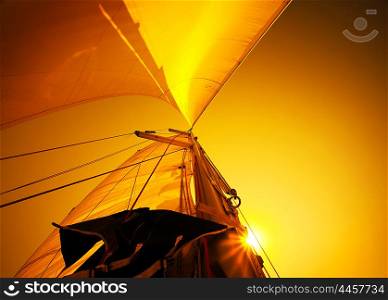 Sail over warm yellow sunset sky, sailboat over natural background