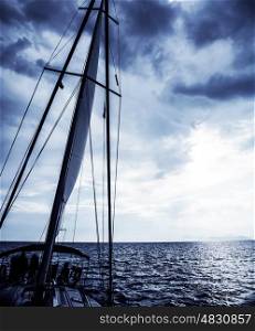 Sailboat at night, luxury water transport, water cruise on sail yacht, yachting sport, cloudy sky, peaceful sea, travel and vacation concept