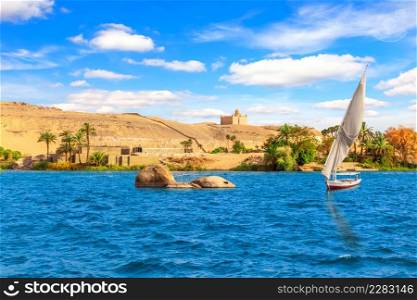Sailboat in the Nile and the view of Aswan, Egypt.. Sailboat in the Nile and the view of Aswan, Egypt