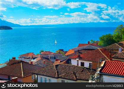 Sailboat on a lake Ohrid. Old town roofs on the foreground. Macedonia