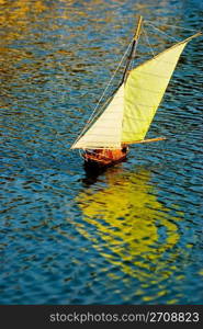 sailboat on the lake with reflection. Handmade remote control sailboat.