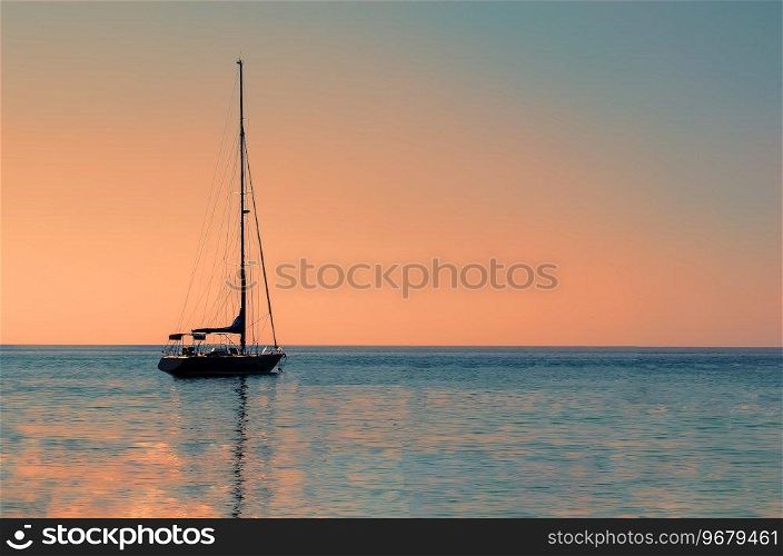 Sailboat or yacht at sea in evening sunlight