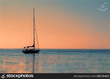 Sailboat or yacht at sea in evening sunlight