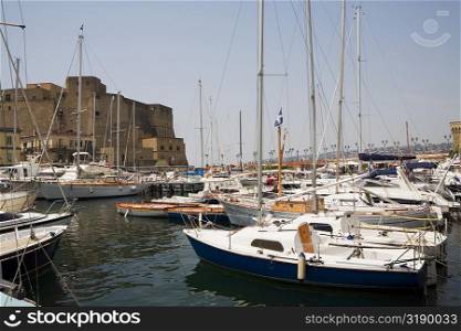Sailboats docked at a harbor with a castle in the background, Borgo Marinaro, Castel Dell&acute;ovo, Bay of Naples, Naples, Naples Province, Campania, Italy