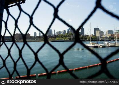 Sailboats in a river seen through a chain-link fence, Boston, Massachusetts, USA