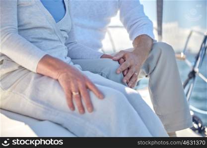sailing, age, tourism, travel and people concept - close up of happy senior couple hugging and talking on sail boat or yacht deck floating in sea