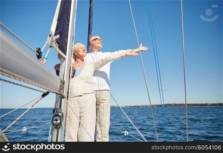 sailing, age, tourism, travel and people concept - happy senior couple enjoying freedom on sail boat or yacht deck floating in sea