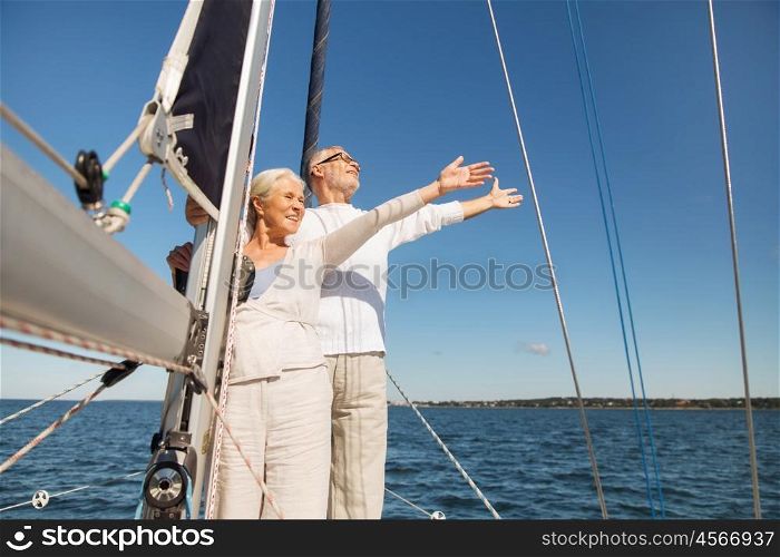 sailing, age, tourism, travel and people concept - happy senior couple hugging on sail boat or yacht deck floating in sea. senior couple hugging on sail boat or yacht in sea
