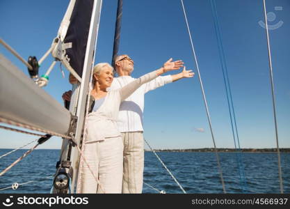 sailing, age, tourism, travel and people concept - happy senior couple hugging on sail boat or yacht deck floating in sea. senior couple hugging on sail boat or yacht in sea